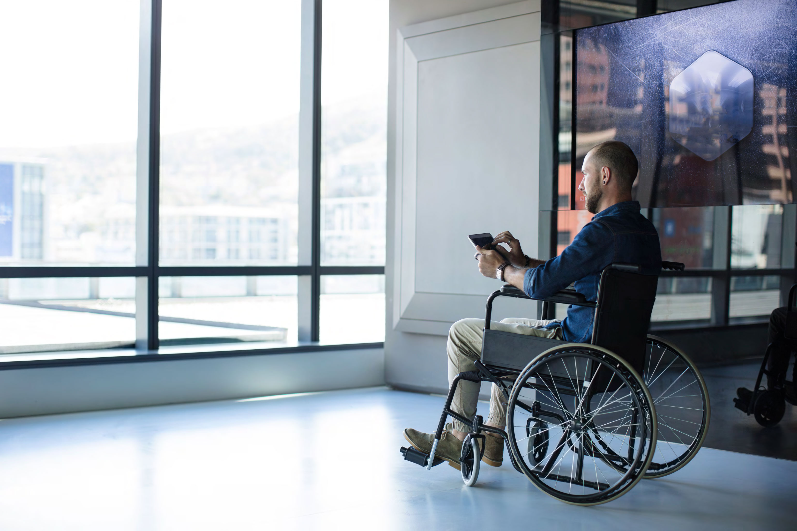 Man in wheelchair using tablet