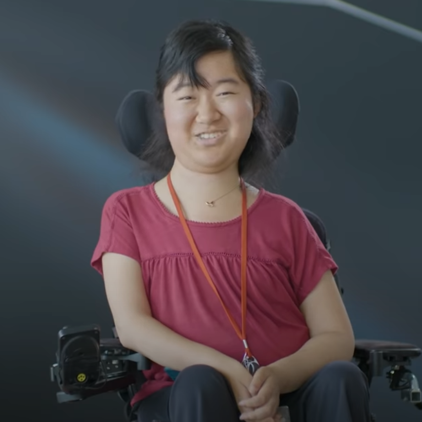 Asian/Pacific Islander smiles in motorized chair