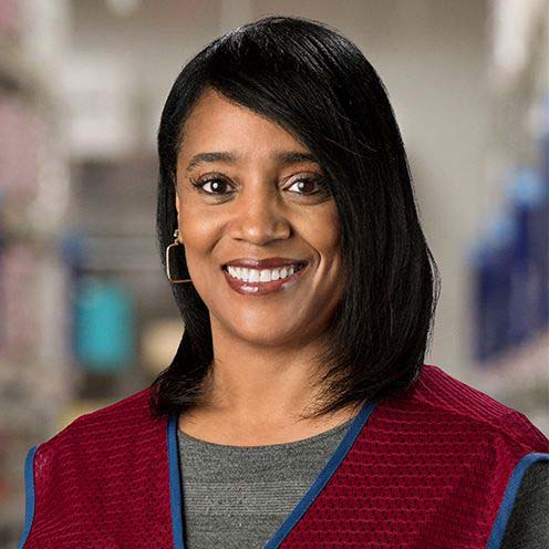 Black woman with shoulder length black hair smiles and wears Lowe's vest