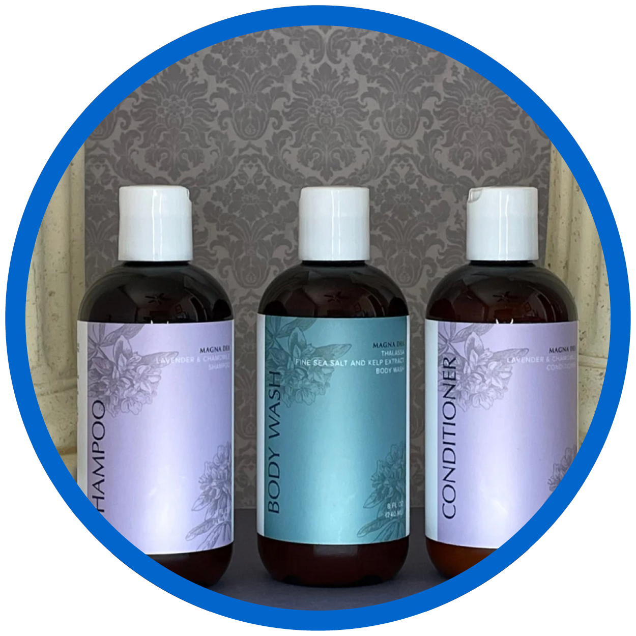 Three bottles of product: Shampoo, Body Wash, and Conditioner with blue and lavender floral designs.