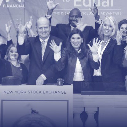 Various people raising their hands at the New York Stock Exchange.